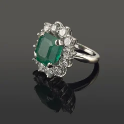 ANILLOS / SORTIJAS Sortija en oro blanco con una esmeralda y orla de brillantes.