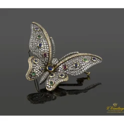 BROCHES / ALFILERES Broche-alfiler mariposa en oro amarillo y plata con rubíes, esmeraldas, zafiros y diamantes naturales.
