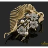 BROCHES / ALFILERES Broche en forma de ramo de flores y hoja realizado en oro amarillo y oro blanco. Presenta perlas, esmeraldas y brillantes.