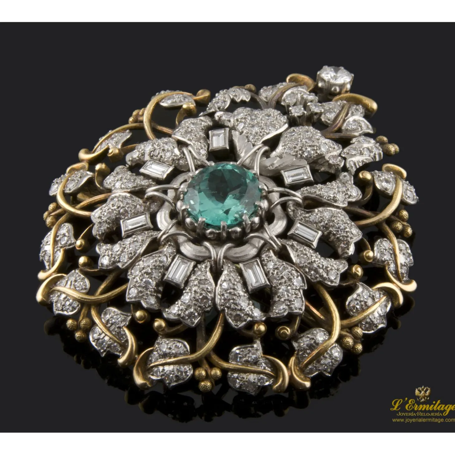 BROCHES / ALFILERES Broche realizado en oro amarillo y oro blanco. Presenta una esmeralda natural colombiana, diamantes y brillante.