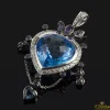 COLGANTES Colgante realizado en oro blanco. Presenta un piedra azul principal con orla de brillantes.