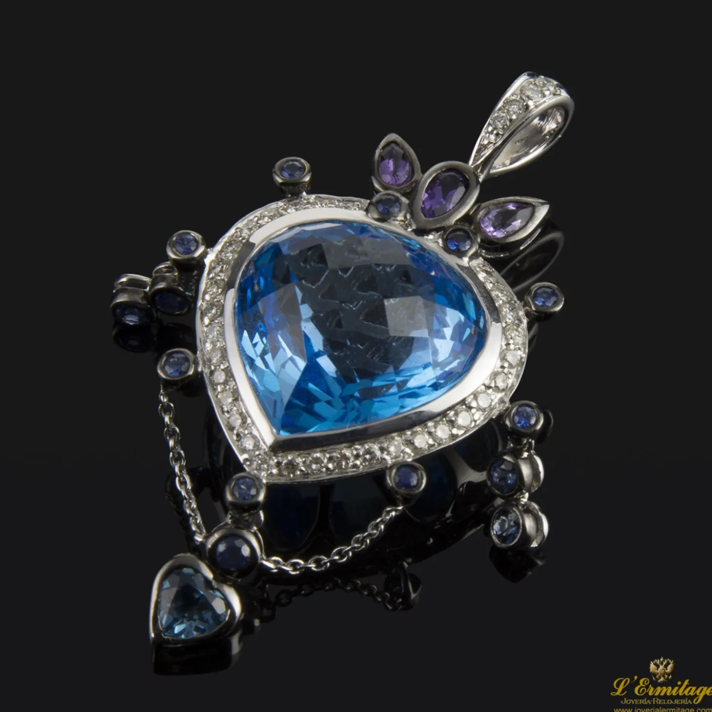 COLGANTES Colgante realizado en oro blanco. Presenta un piedra azul principal con orla de brillantes.