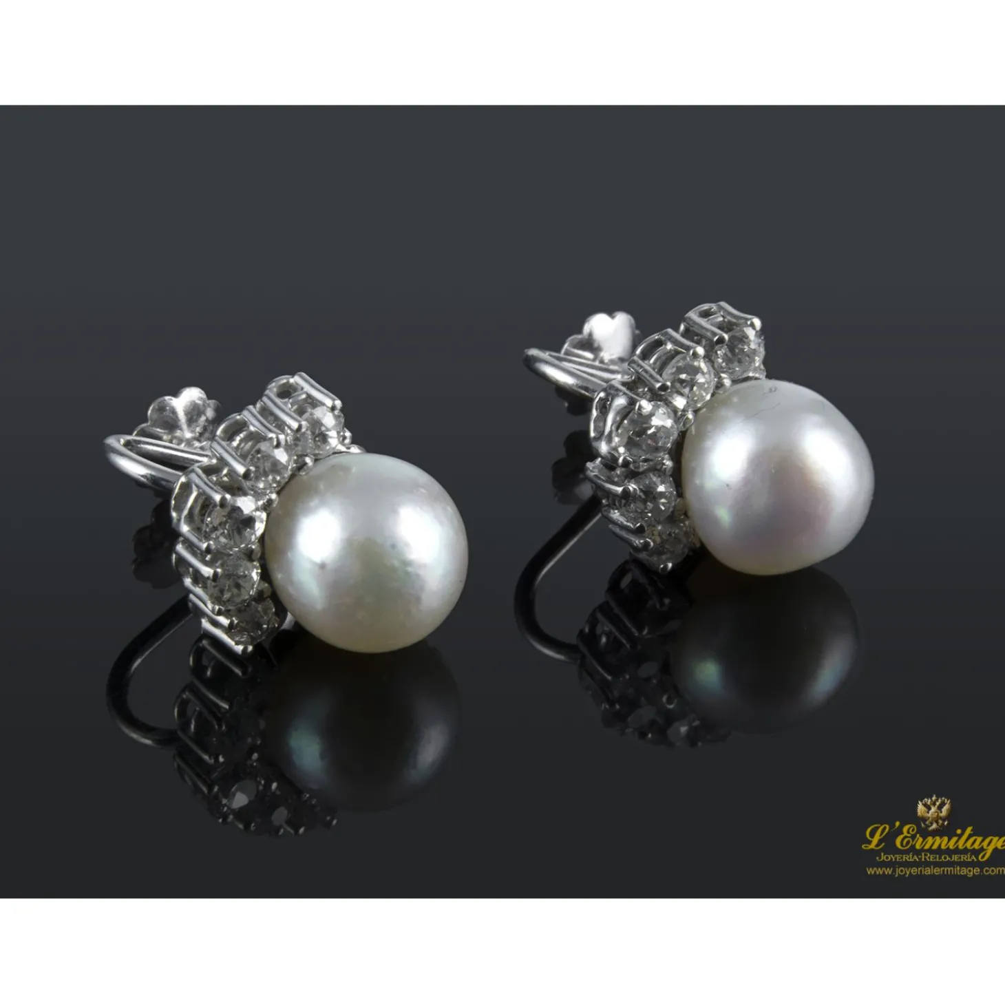 PENDIENTES Pendientes de perlas naturales realizados en oro blanco con medialuna de brillantes.