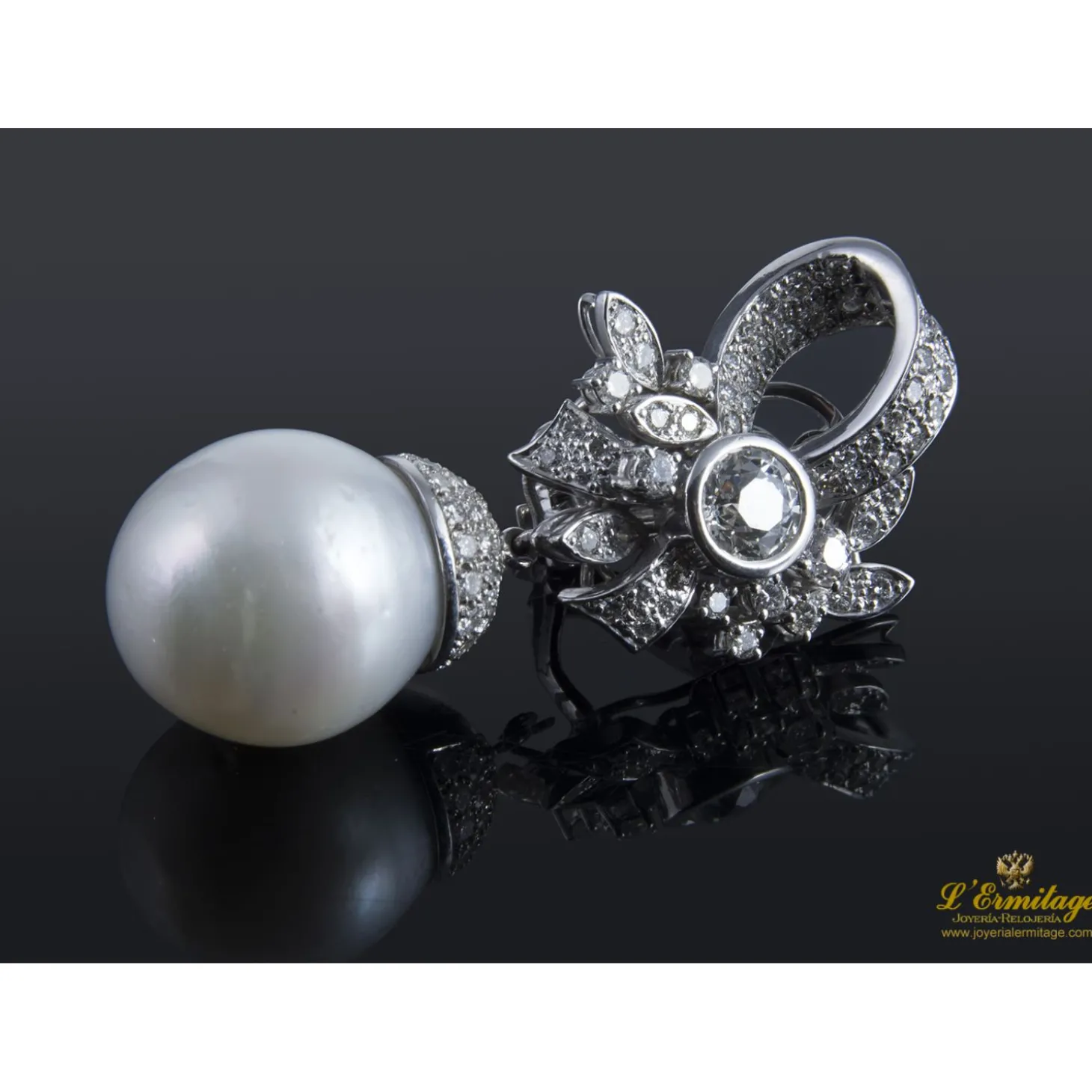 PENDIENTES Pendientes desmontables en forma de lazo realizados en oro blanco. Presenta perlas australianas y brillantes.