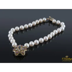 PULSERAS Pulsera de perlas con cierre en oro amarillo con forma de flor.