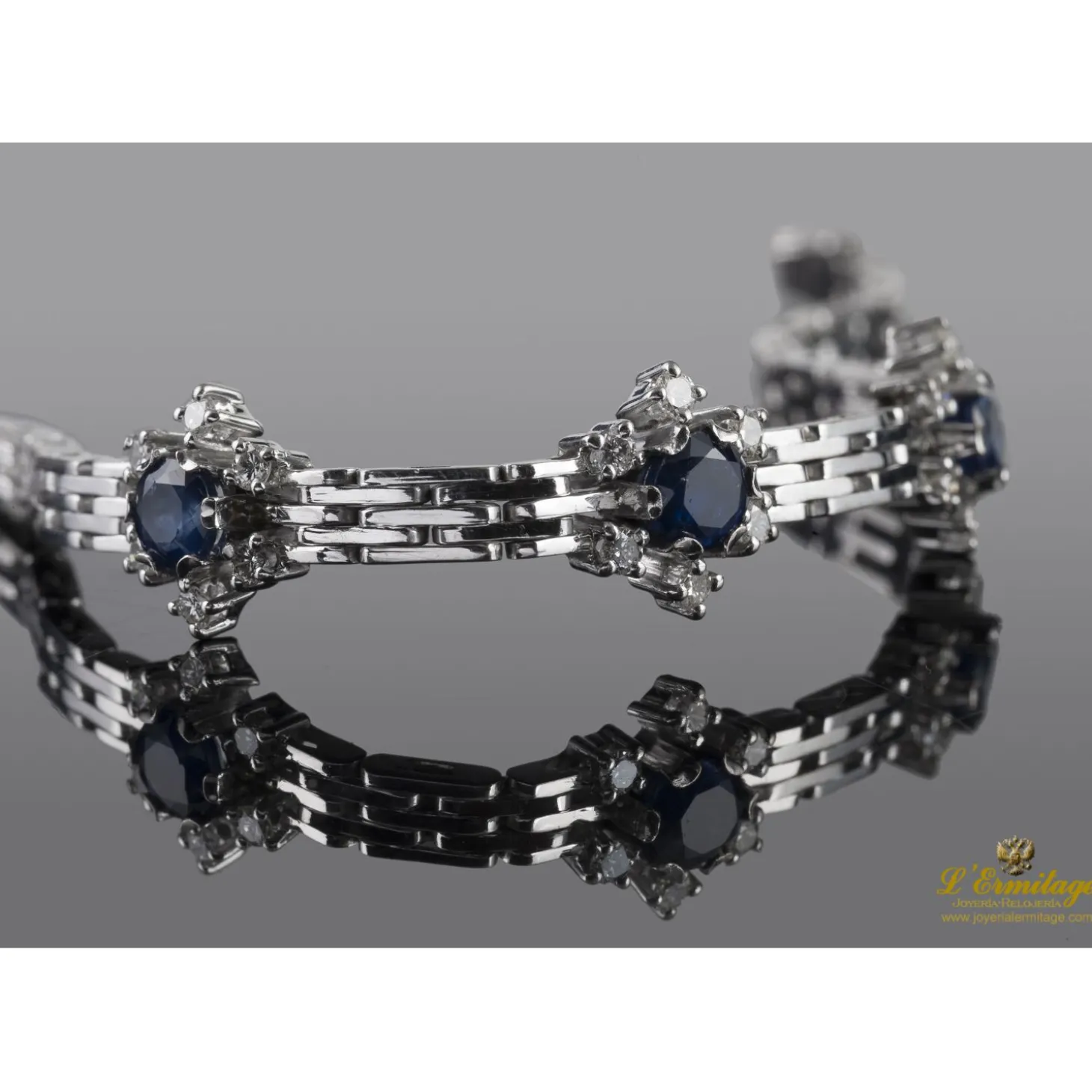 PULSERAS Pulsera en oro blanco con motivos en rosetas de zafiros y brillantes.