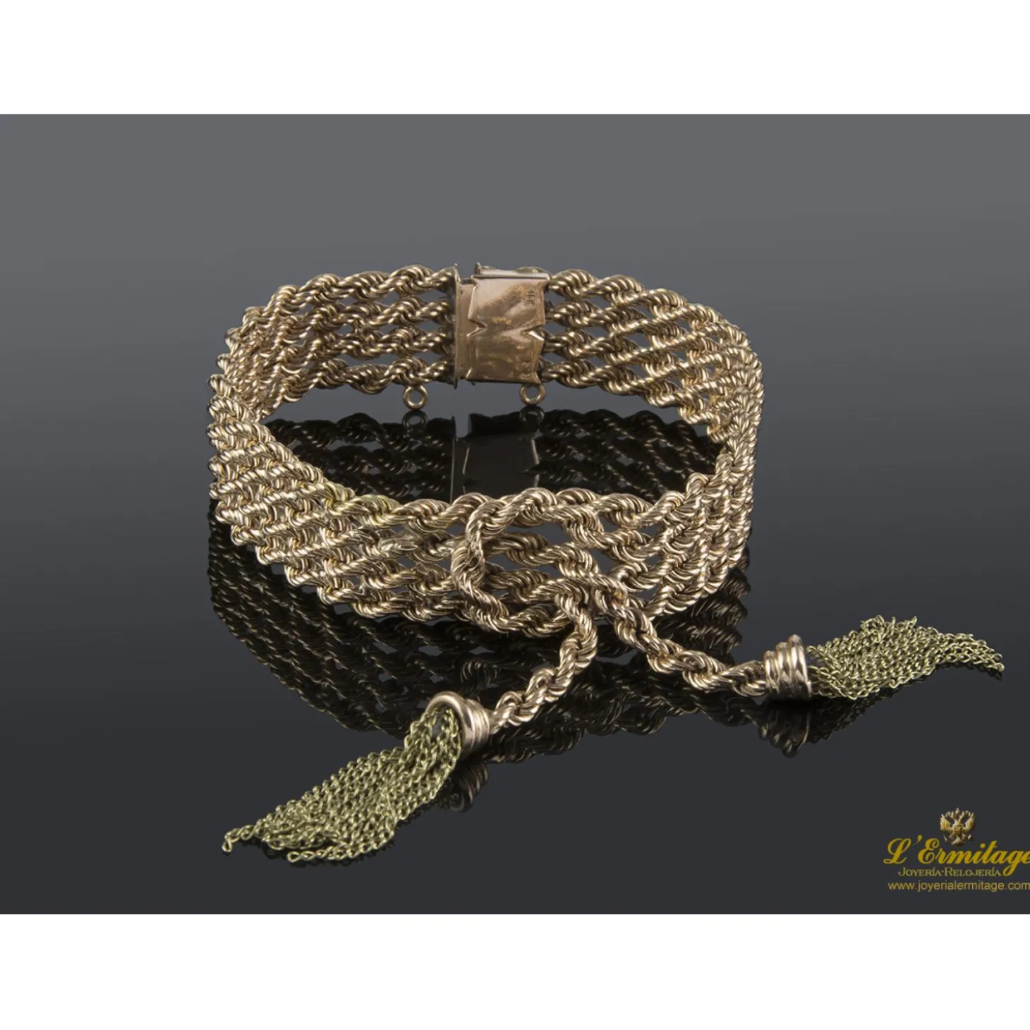 PULSERAS Pulsera realizada en oro rosa y oro amarillo con forma de cuatro trenzas en fila con un nudo y flecos.