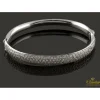 PULSERAS Pulsera rígida de media caña con centro pabe de brillantes montados en oro blanco.