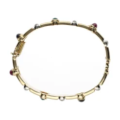 PULSERAS Pulsera rígida en oro amarillo con zafiros, rubíes, esmeraldas y brillantes.